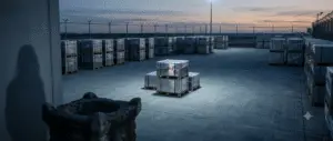 A single sealed stainless steel box with a fresh red stamp in a customs warehouse at dawn, with an ancient stone altar shadow out of focus.